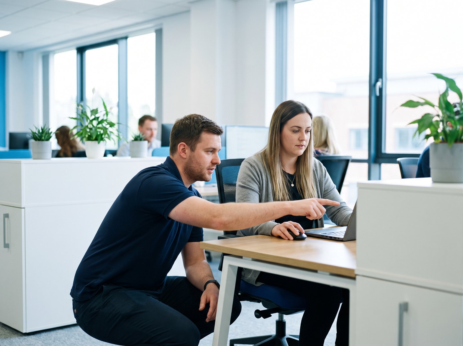 IT support engineer helping an office worker at her desk